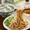 胡麻ダレたっぷりの台湾涼麺と、湯気が立ち上る貢丸スープのセット。箸で持ち上げた麺に濃厚な胡麻ダレが絡む本格台湾料理。