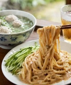 胡麻ダレたっぷりの台湾涼麺と、湯気が立ち上る貢丸スープのセット。箸で持ち上げた麺に濃厚な胡麻ダレが絡む本格台湾料理。
